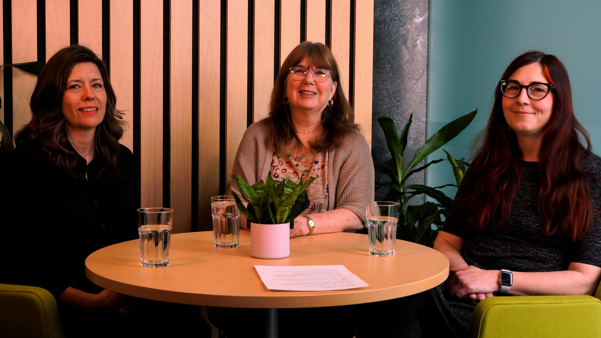 Three speakers sitting around a table for an interview 